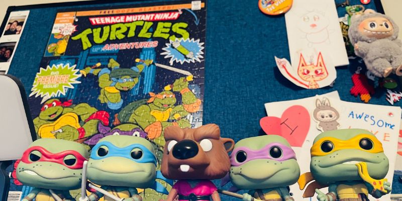 Teenage Mutant Ninja Turtles Funko Pop figures displayed in front of a colorful comic book cover.
